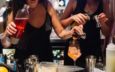 Bartenders Mixing Colorful Cocktails Behind Bar.