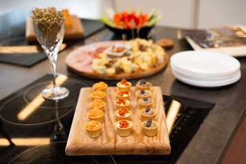 Mini savory tartlets on wooden serving board.