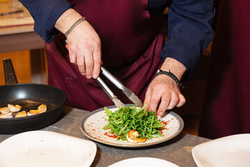Chef Plating Shrimp and Arugula Salad.
