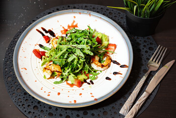 Gourmet shrimp salad with strawberries and arugula.