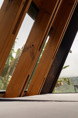 Three sturdy wooden beams stand as columns in a refined rustic cabin design. Their polished finish...