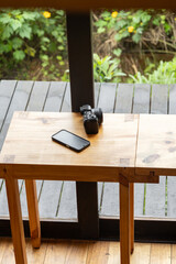 A refined wooden table stands gracefully in front of a large window, flooded with natural light. The scene evokes elegance, serenity, and timeless interior style.

