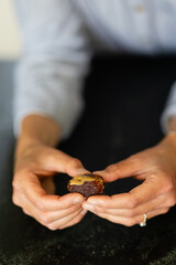 woman's hands holding medjool date topped with peanut butter