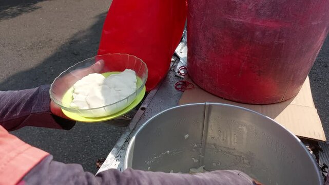 The toufu fa (tauhua, soybean custard, kembang tahu) seller is transferring the taufu fa from the pot to the bowl. Toufu fa is a dessert made from soybean and is a popular dish among peranakan Chinese