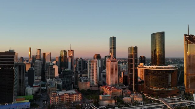 Brisbane CBD, Queensland, Australia: 4K Aerial Sunset Image Featuring City Skyline, Skyscrapers, the Star Brisbane Casino, Brisbane River, Bridges, City Highway and Traffic in Warm Evening Light