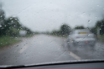 Rain drop on the car glass window while driving on the road.