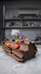 uncut chocolate roll cake topped with long chocolate chips and small fruits