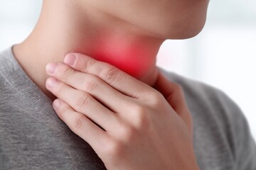 Close-up of a woman with sore throat holding her neck, demonstrating discomfort and pain in the throat area, on a light blurred background