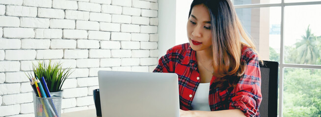 Banner Woman typing laptop computer online meeting at home office work from home. Asian...