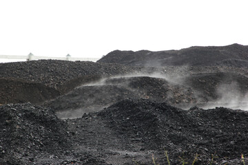 Coal piles with rising steam at industrial site