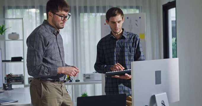 Team adult male engineer collaborate on robotic hand project using AI code solutions machine learning at tech workspace. Artificial intelligence interface, collaboration support prototype development.