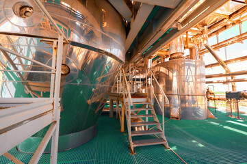 Pipelines and large storage tanks inside a chemical plant showcasing industrial operations during the day