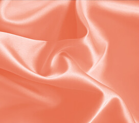 Fototapeta premium Peach, coral, crepe, persian, dusty colorful fabric. Orange pink silk satin background. Folded material with blank space for text. Twisted curve, curl. Juicy fashion sample, template. Abstract drape.