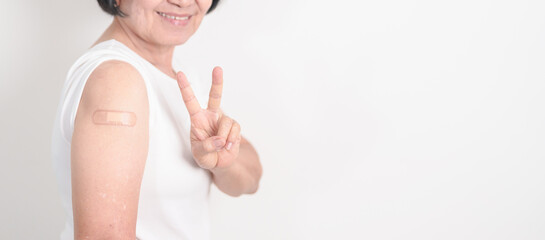 Elderly Woman with bandage after received vaccine. Vaccination and Immunization for Influenza, Herpes Zoster, Tetanus, Covid 19 booster, Dengue, Encephalitis, Rabies, Pneumococcal, IPD, RSV Vaccines