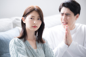 カップルで喧嘩をして謝る男性と女性　ごめんなさいと謝る上半身