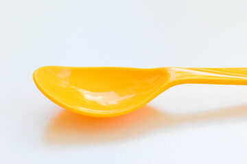 yellow spoon isolated on white background, plastic cutlery for picnic