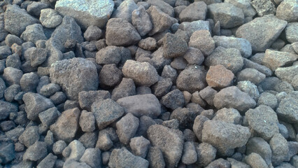 A collection of small gravel stones commonly used for construction, landscaping, or as a base layer in roads and pathways. These pebbles vary in size and color, offering a natural and durable surface.