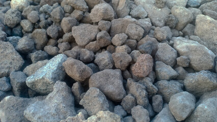 A collection of small gravel stones commonly used for construction, landscaping, or as a base layer in roads and pathways. These pebbles vary in size and color, offering a natural and durable surface.