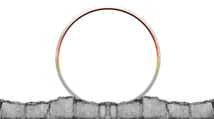 Large circular metal ring stands upright cracked concrete surface, creating striking contrast between smooth metallic texture and rough, broken ground. scene evokes sense of mystery and intrigue