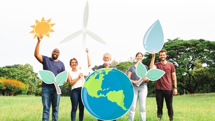 Diverse group holding eco-friendly symbols: wind turbine, water drop, globe, leaves. Outdoor setting, promoting sustainability and environmental awareness. Environmentalists in nature holding signs.