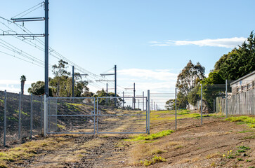 A fenced-off maintenance or gated utility access track alongside a suburban Melbourne railway line...