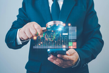 Businessman use magnifier glass find stock in stock markets, uptrends, growth economics, business strategy development, and opportunities for investment, take profit from funds, Financial Analyst.