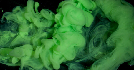 Smoke stream. Dye spread. Bright color green paint explosion flow. Art fume wave spray abstract blur black sparkling water background.