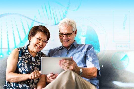 Senior couple using a digital device in a living room