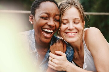 Happy black woman laughing with her friend