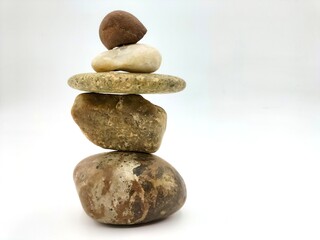 Rocks on a white background, the art of arranging rocks vertically in a Zen style that conveys...