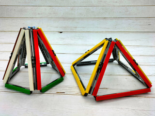 Create art by connecting plastic blocks to form pyramid, equilateral triangle, and isosceles triangle structures. This is art installation that can also be used as a teaching aid for geometry.