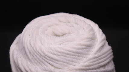 A ball of yarn in an orange color on a black background