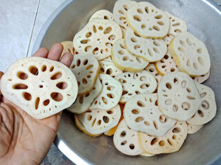 Lotus roots are washed and thinly sliced and ready to be used in a delicious dessert that has both...