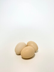 Three fresh chicken eggs on a clean isolated white background. 