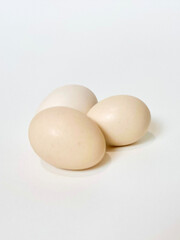Three fresh chicken eggs on a clean isolated white background. 
