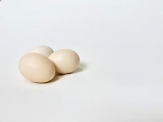 Three fresh chicken eggs on a clean isolated white background. 