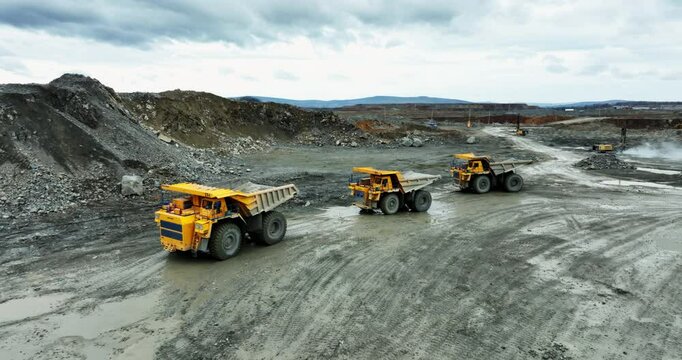 Mining trucks transporting minerals in open pit mine. Stock clip