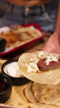 Preparing Tlayudas with Grilled Meat and Vegetables