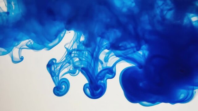 Vibrant blue ink swirling and dispersing in clear water, creating organic, flowing abstract patterns. Ideal for concepts of creativity, chemical reactions, diffusion, or dynamic fluid motion.