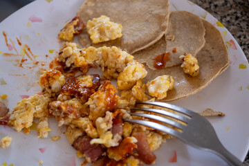 huevo revuelto con tocino y salsa con tortillas