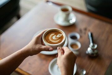 Holding a cup of café latte or coffee lover