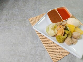 Siomay Bandung (Shumay) or steamed dumplings with boiled egg, tofu, potato, bitter melon and...
