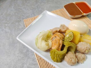 Siomay Bandung (Shumay) or steamed dumplings with boiled egg, tofu, potato, bitter melon and...