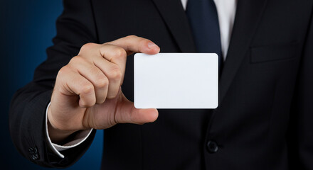 Fototapeta premium Elegant businessman in suit holding a blank business card