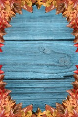 Wooden plank surface is featuring rustic flat design with autumn leaf border in muted blue
