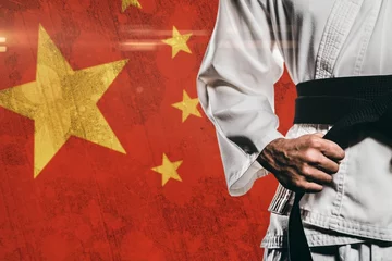 Midsection of martial artist against Chinese Flag