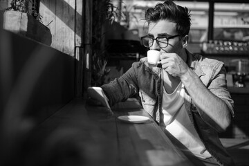 Man using mobile phone while having cup of tea