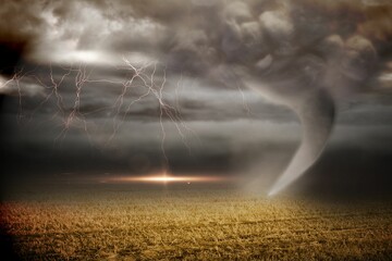 Stormy sky with tornado over field