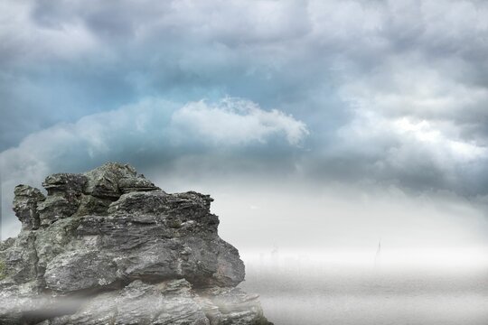 Fototapeta Flat design showing rock formation left, calm water, mist shrouding distant skyline, cloudy sky