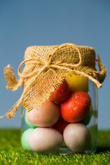 Easter eggs in jar on field